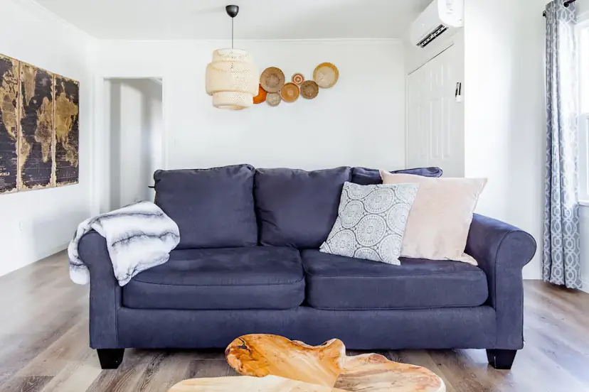 Navy sofa under a rattan pendant and woven baskets