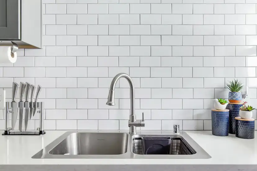 Stainless sink under white subway tile