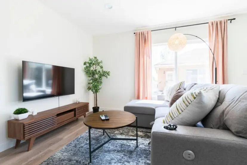 Living room with a grey sectional and a wall TV