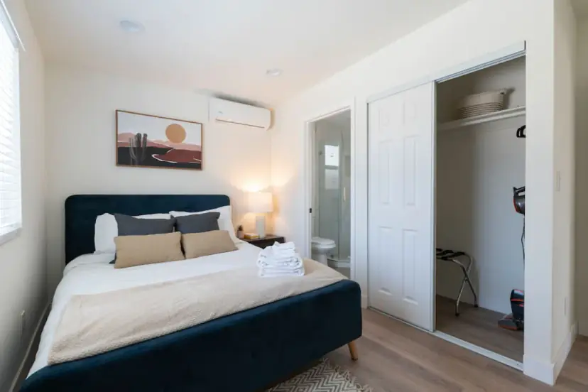 Bedroom with a navy velvet bed and an open closet