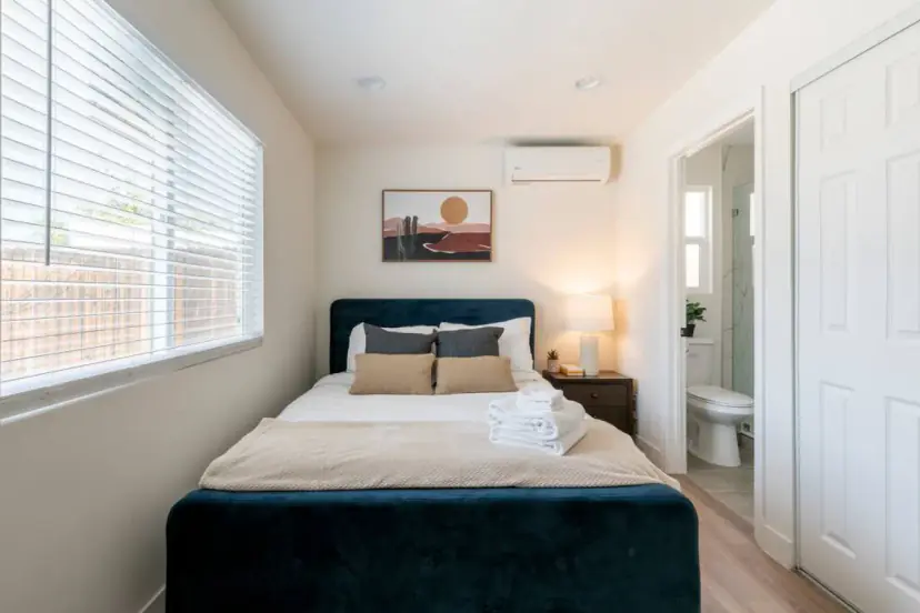 Bedroom with a navy bed and the bathroom beyond
