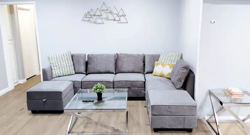 Living room with a grey sectional and a glass coffee table
