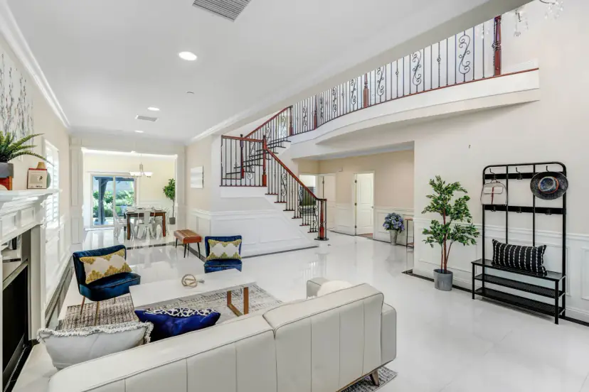 Living room below a curved staircase and an open landing