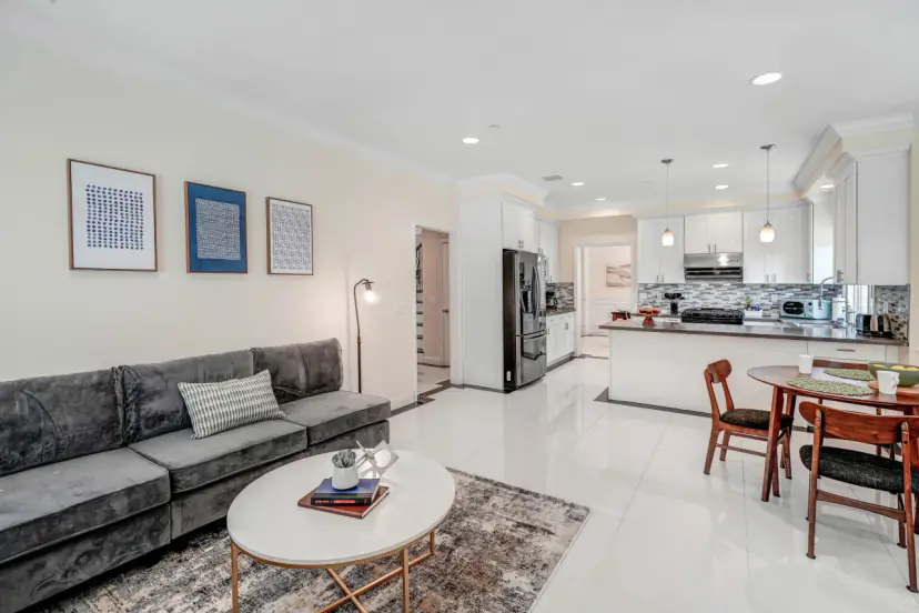 Family room with a grey sectional, open to the kitchen and breakfast table