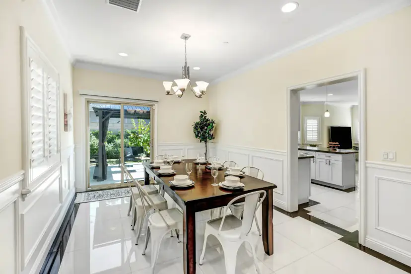 Dining room with wainscoting, a chandelier and a table set for eight