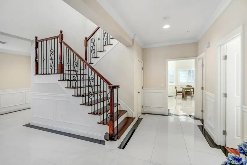 Entry hall with a curved staircase and iron railings
