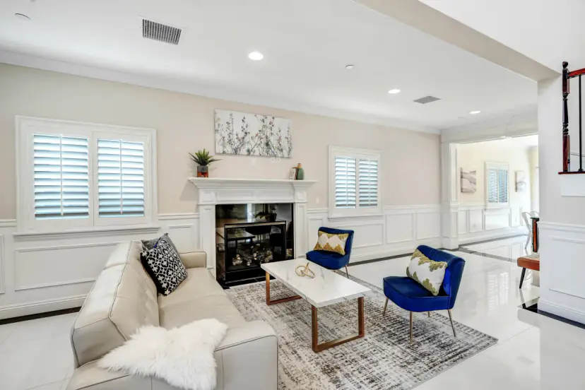 Fireplace with a white mantel between shuttered windows