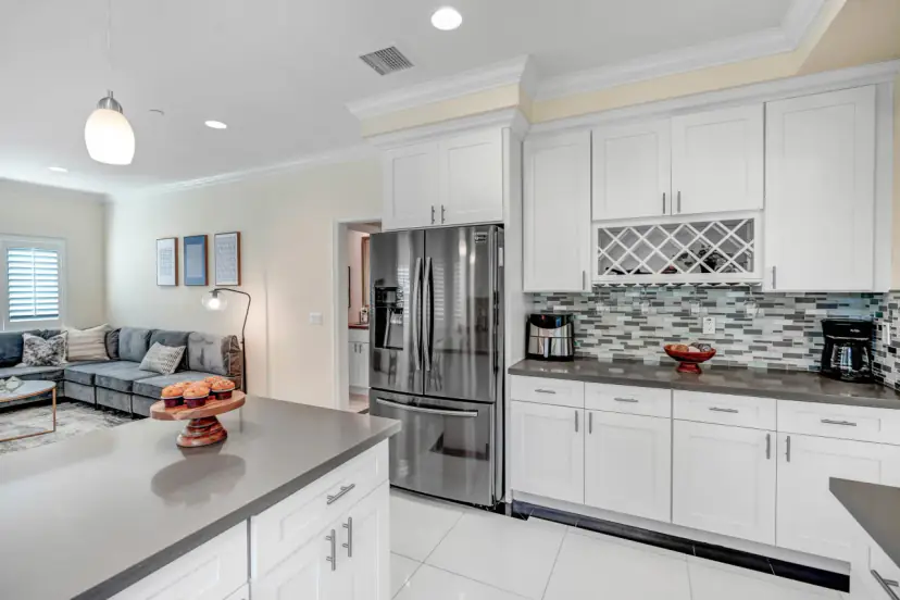 Kitchen with white cabinets, a wine rack and a stainless fridge