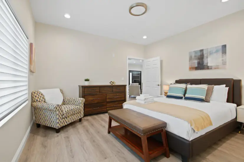 Main bedroom with a queen bed and an armchair