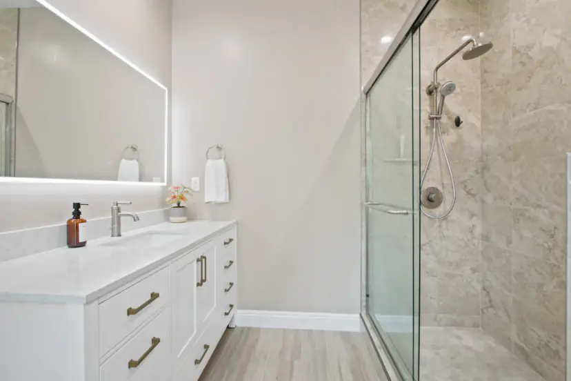 Bathroom with a lit mirror and a glass shower