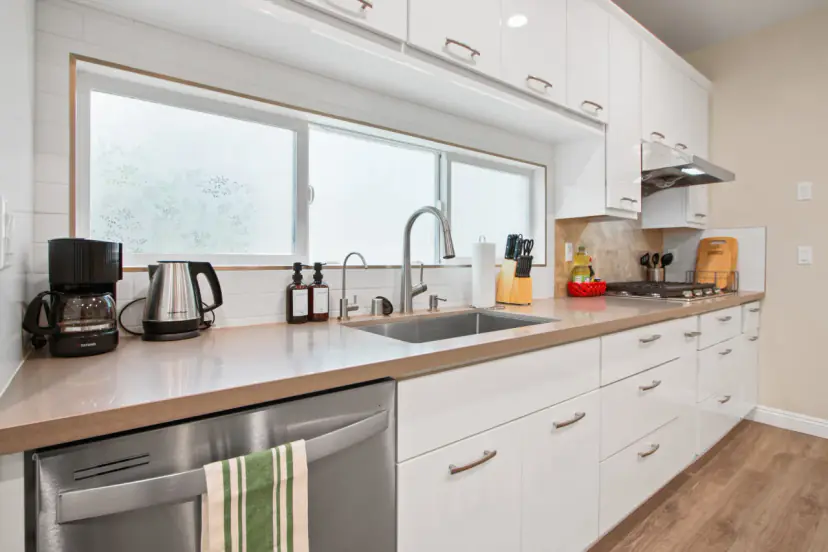 White kitchen with a double window and a dishwasher