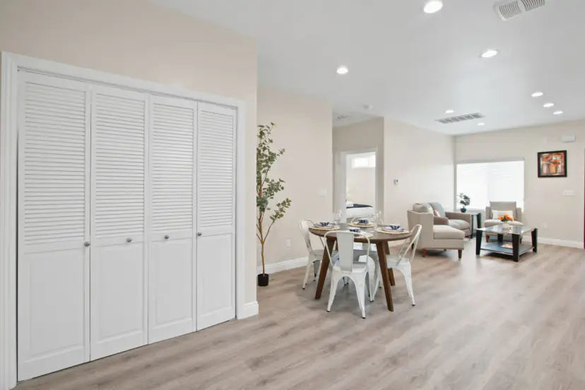 Open dining and living room with a louvred closet