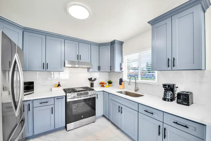 Blue-grey shaker kitchen with a steel range and sink