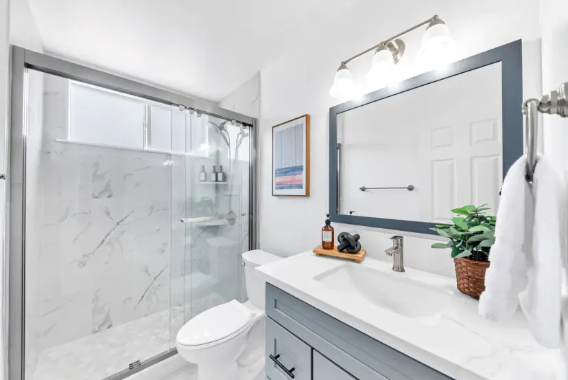 Bathroom with a marble-look shower and a grey vanity
