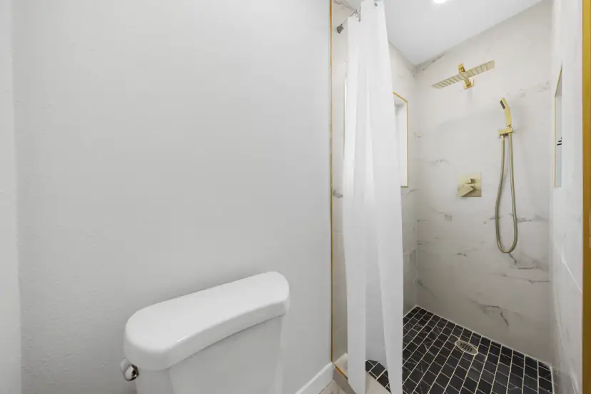 Walk-in shower with a gold rain head