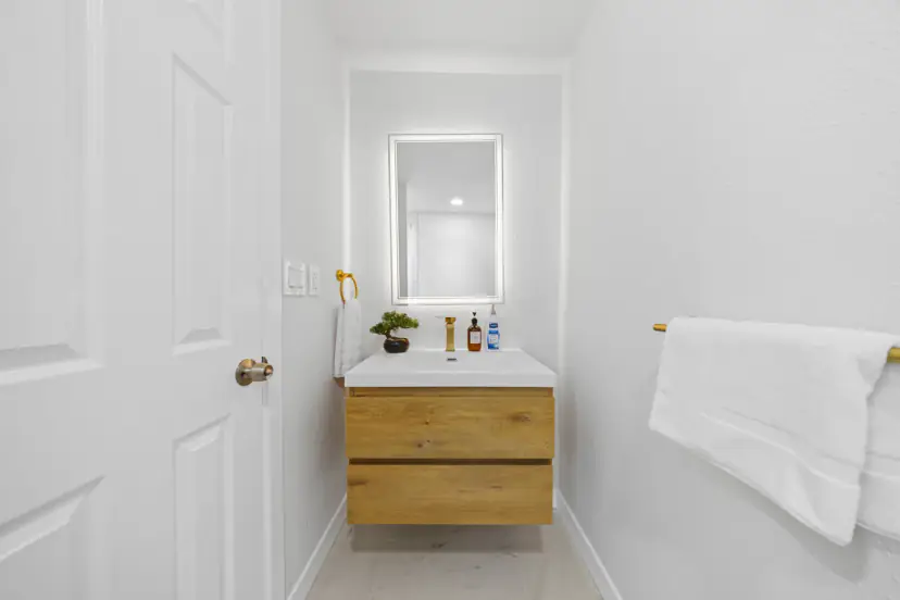 Vanity with a lit mirror and floating wood cabinet