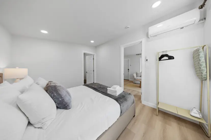 Queen bed with a view through to the living room