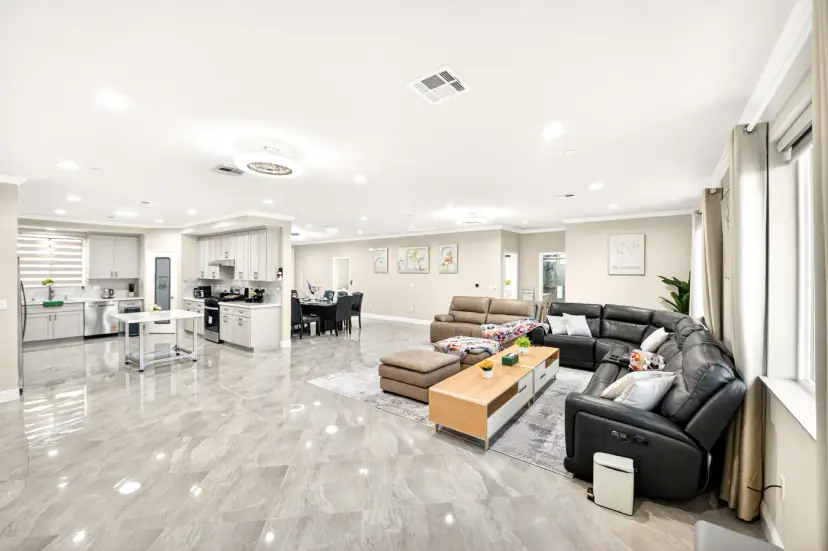 Open-plan living room, dining area and kitchen with glossy tile floors