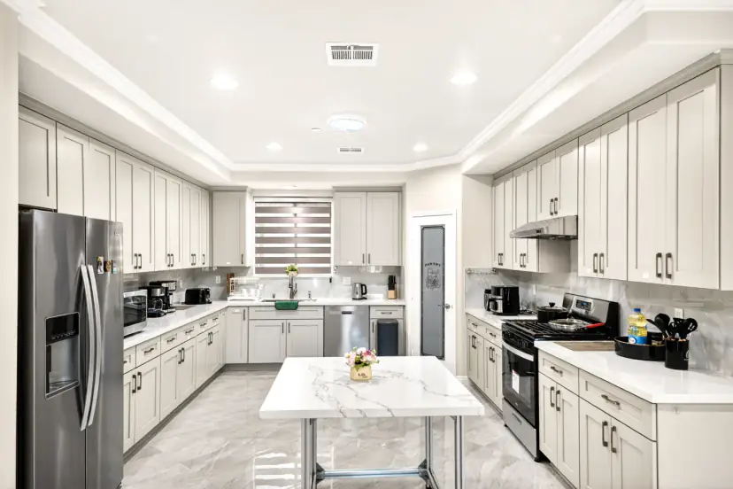 Grey shaker kitchen with a marble-top island cart and gas range