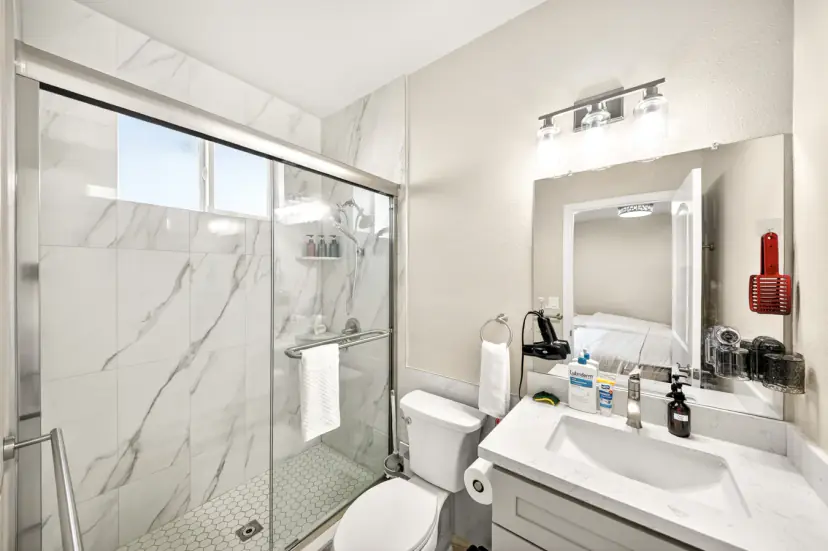 Bathroom with a large glass shower and marble-look tile