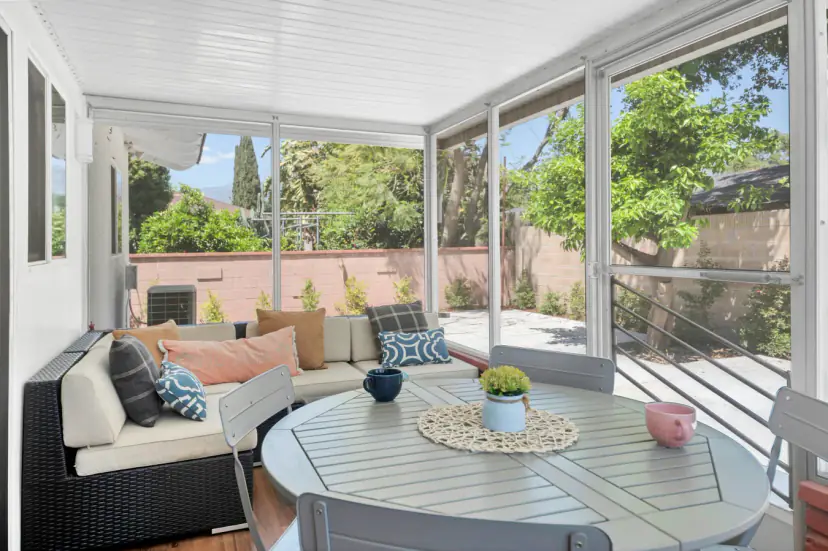 Enclosed patio with a round dining set and lounge seating