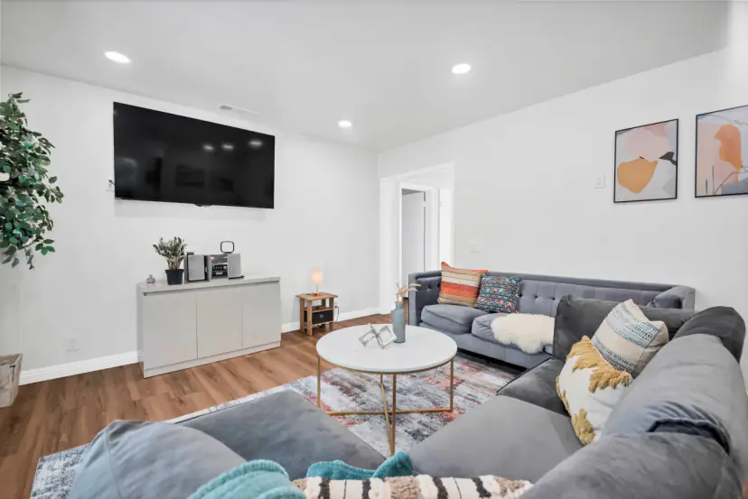 Living room with a grey sectional and a wall TV