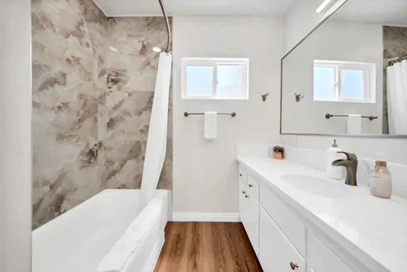 Bathroom with a marble-look tub-shower and a long vanity