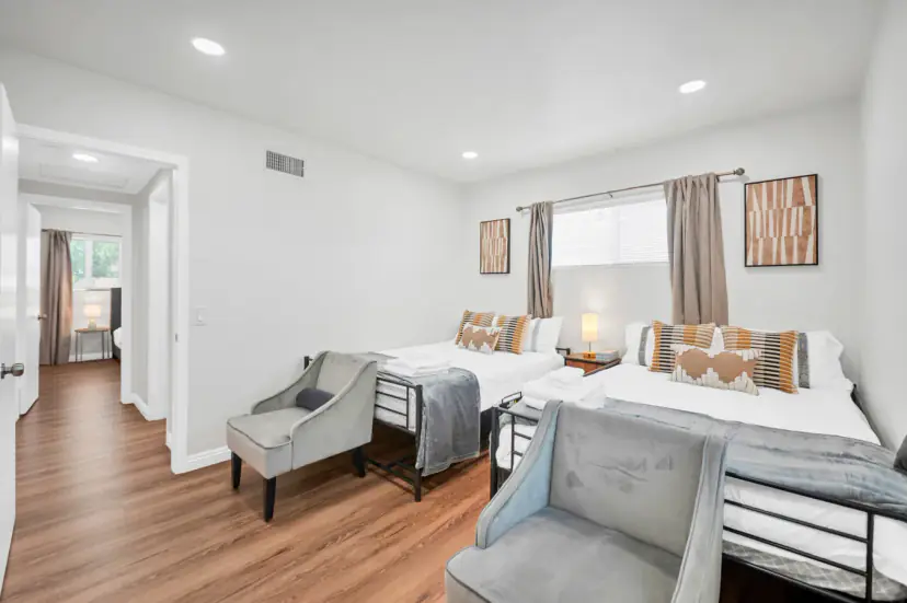 Bedroom with two double beds and two armchairs