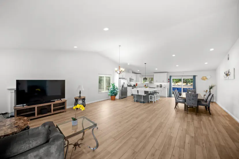 Open great room with a TV, dining and kitchen