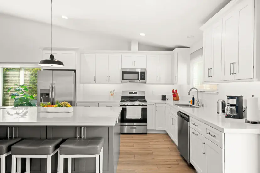 White kitchen with a grey island and stools
