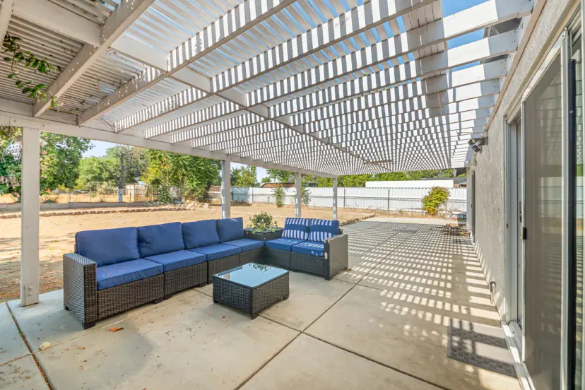 Patio sectional under a white pergola