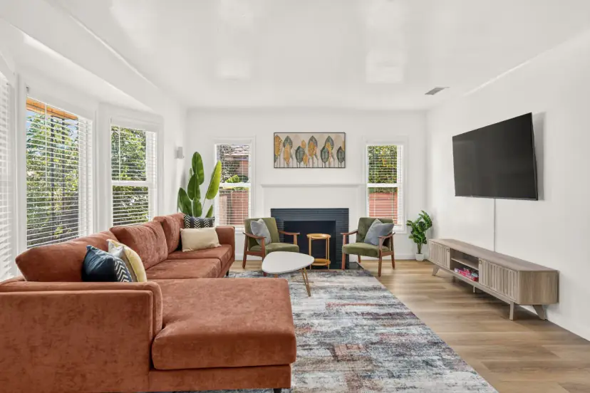 Living room with a rust velvet sectional and a navy-tiled fireplace