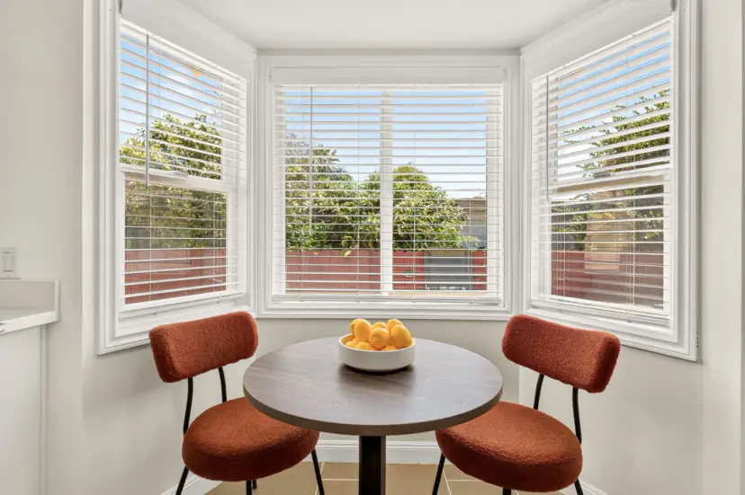 Bay-window breakfast nook with rust velvet chairs