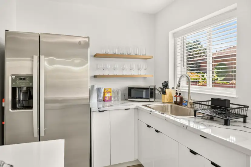 Kitchen with a stainless fridge and open shelves