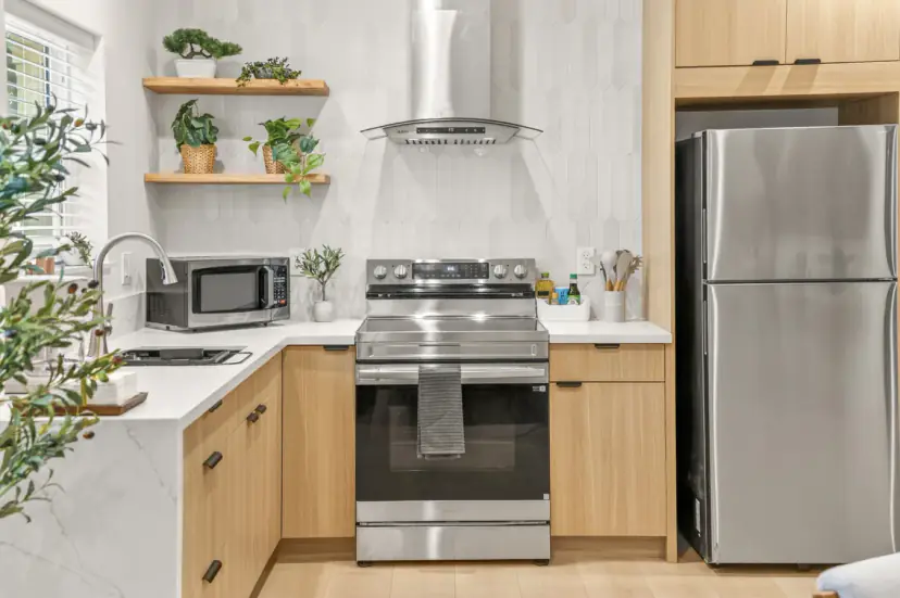 Kitchen with a stainless fridge, a range and open shelves