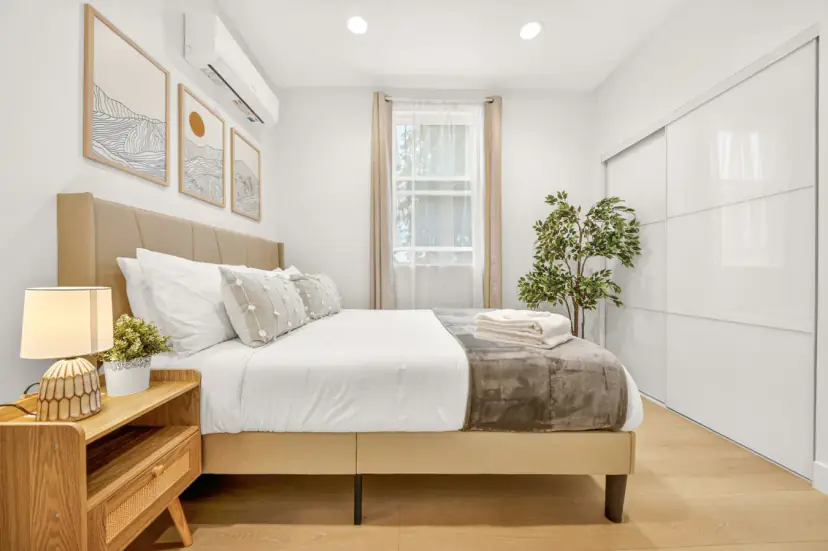 Bedroom with a wood bed, mountain prints and a white sliding wardrobe