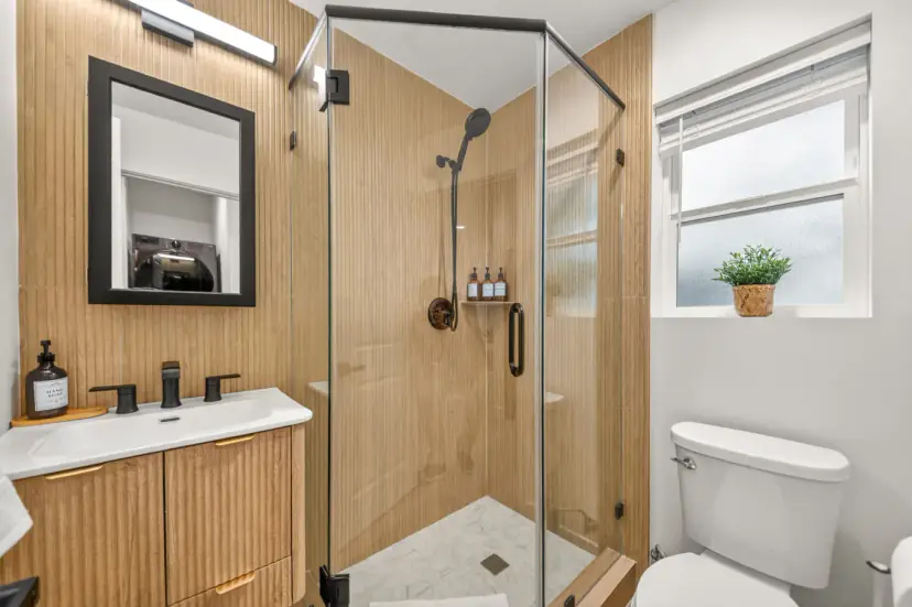 Bathroom with a fluted wood vanity and a glass walk-in shower