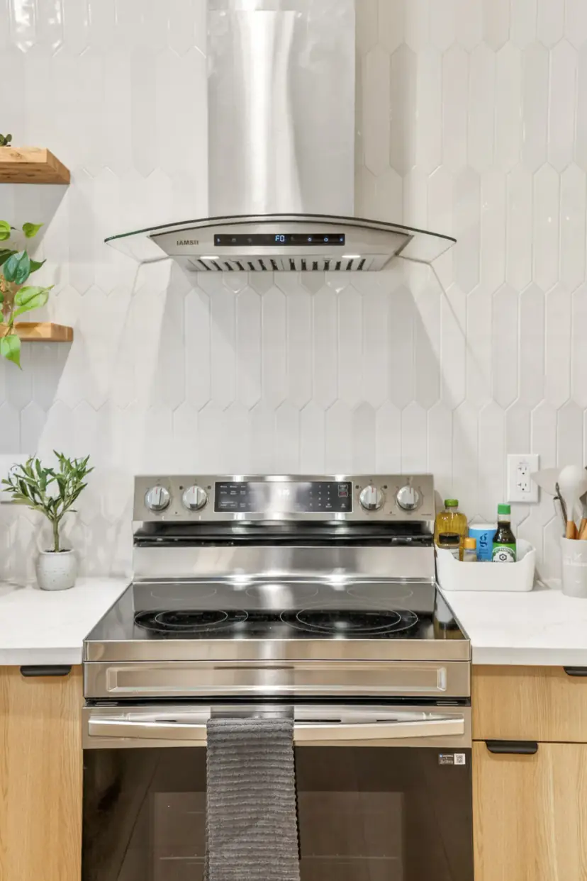 Range under a stainless hood and white tile