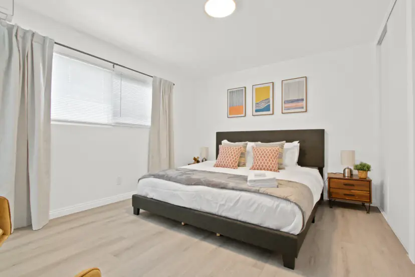 Bedroom with a dark headboard and abstract prints