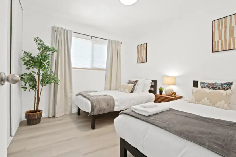 Twin bedroom with two beds and a plant