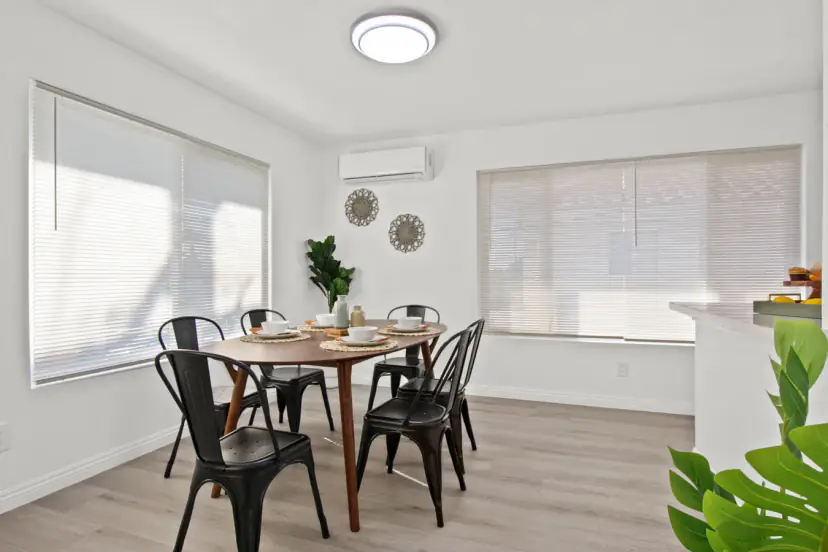 Dining table with black metal chairs by the windows