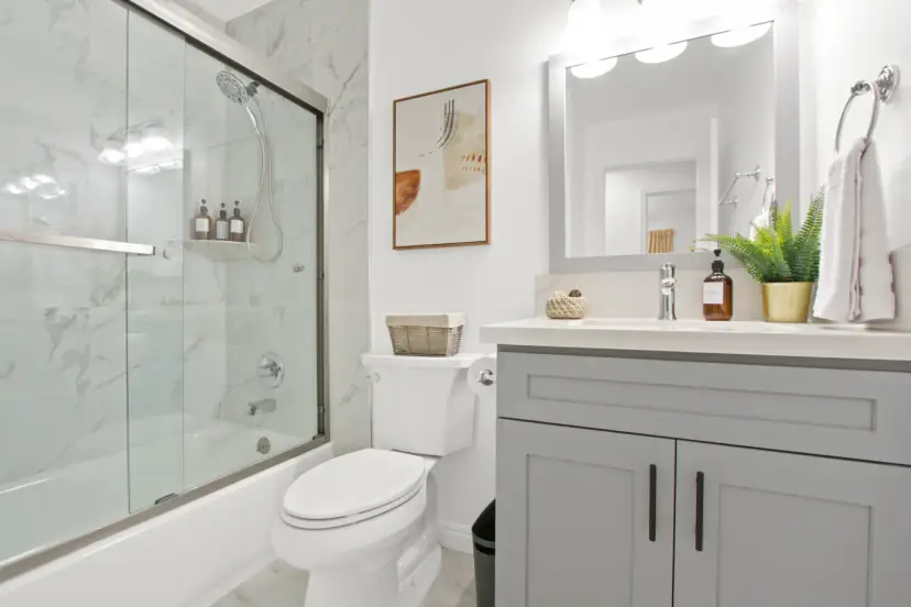 Bathroom with a glass tub enclosure and a grey vanity