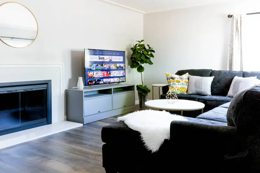Navy sectional facing a white fireplace and a TV