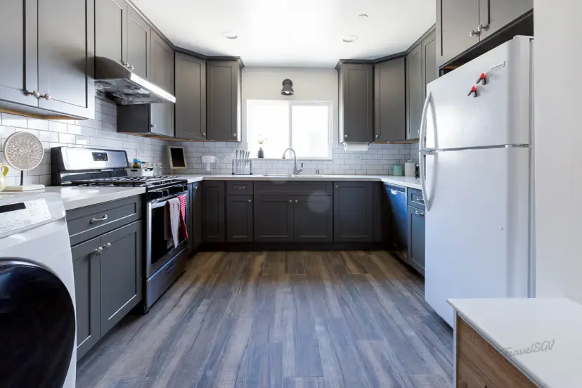 Charcoal shaker kitchen with a gas range and white fridge