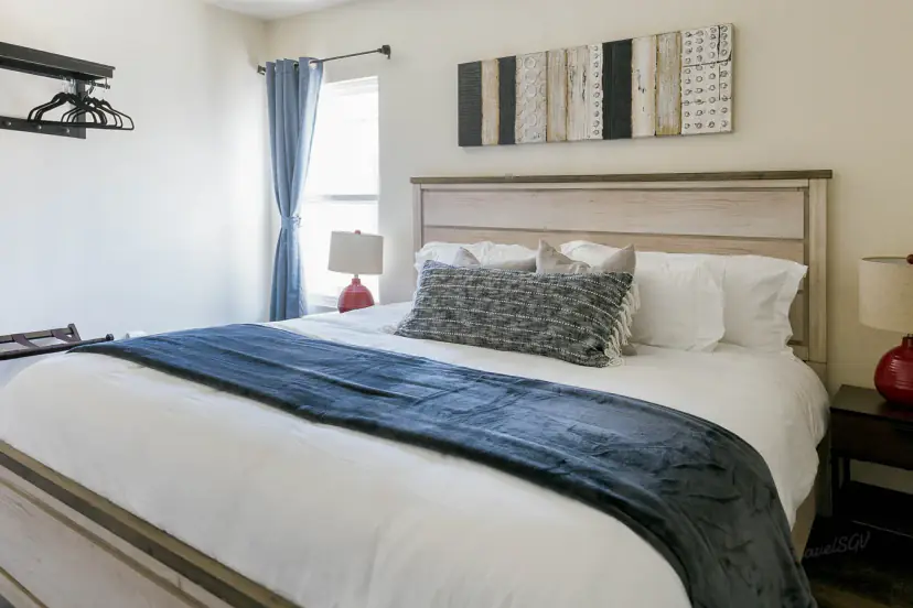 Bed with a navy throw and red lamps