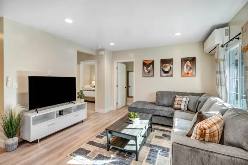 Living room with a grey sectional and a wall TV