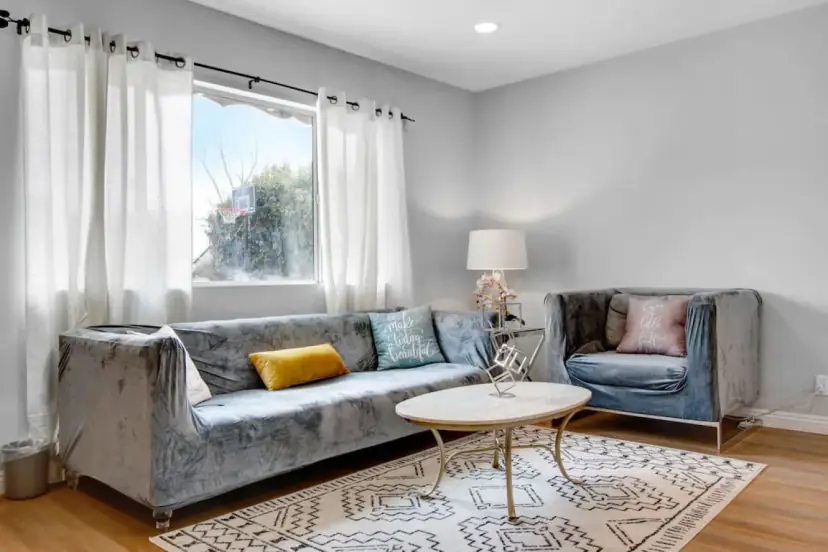 Living room with a blue-grey velvet sofa and a round coffee table