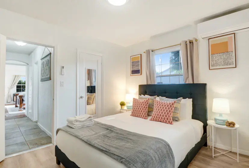 Bedroom with a queen bed, a dark headboard and coral pillows