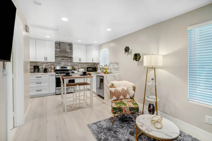 Open living room and kitchen with an armchair and a round coffee table