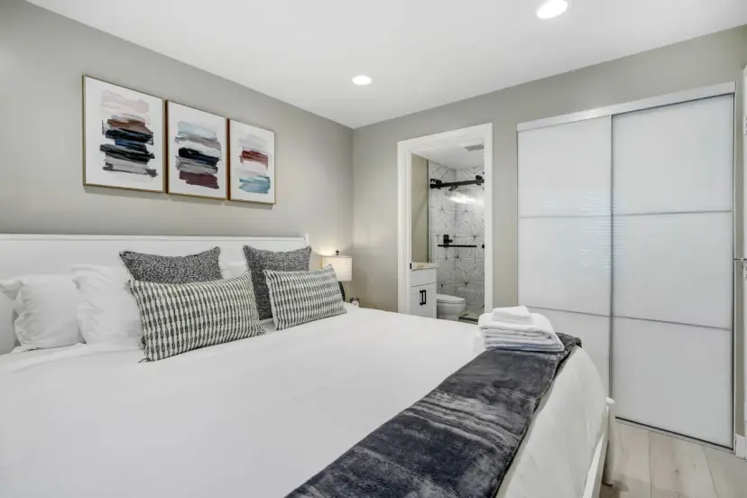 King bed with grey pillows and a sliding closet